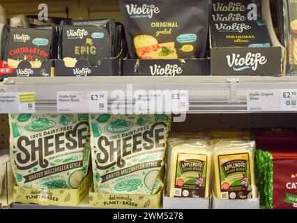 Londres, Royaume-Uni. 24 février 2024. Alternatives de fromage à base de plantes dans un supermarché londonien. Les alternatives laitières pourraient être contraintes de changer de nom et de cesser d'utiliser des variantes pour des termes tels que "lait", "beurre" et "fromage" en vertu des nouvelles règles proposées qui prétendent éviter toute confusion entre produits végétaux et produits laitiers. La proposition a été critiquée par les fabricants d'aliments d'origine végétale. Crédit : Vuk Valcic/Alamy Live News Banque D'Images