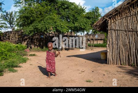 Un jeune garçon Massaï vêtu d'un shuka marche à travers son vilage à Mikumi, en Tanzanie Banque D'Images