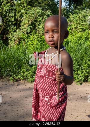 Un jeune garçon Massaï vêtu d'un shuka marche à travers son vilage à Mikumi, en Tanzanie Banque D'Images