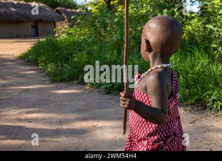 Un jeune garçon Massaï vêtu d'un shuka marche à travers son vilage à Mikumi, en Tanzanie Banque D'Images