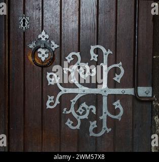 Sculpté, fantaisie, argenté peint charnière de porte en fer forgé à l'intérieur de la porte d'entrée en bois à l'église paroissiale de Wimborne Minster, Royaume-Uni Banque D'Images