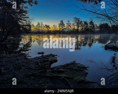 Godalming, Royaume-Uni. 24 février 2024. Jeudi Common, Elstead. 24 février 2024. Un début de journée glacial pour les Home Counties. Lever du soleil sur Elstead Moat à jeudi commun près de Godalming dans le Surrey. Crédit : james jagger/Alamy Live News Banque D'Images