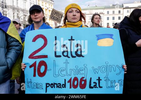 Cracovie, Pologne, 24 février 2024. Une femme tient une bannière alors qu'elle assiste à une marche de soutien et d'union à l'occasion du deuxième anniversaire de l'invasion à grande échelle de l'armée russe en Ukraine sur la place du Vieux marché dans la vieille ville de Cracovie. La marche vise à montrer l'unité du peuple polonais ukrainien ainsi que le soutien de l'opposition russe et biélorusse à la lutte ukrainienne. Crédit : Dominika Zarzycka/Alamy Live News Banque D'Images