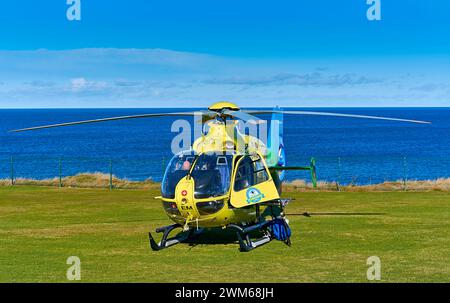 Scottish Air Ambulance L'hélicoptère sur GRASS Moray Coast Scotland Banque D'Images