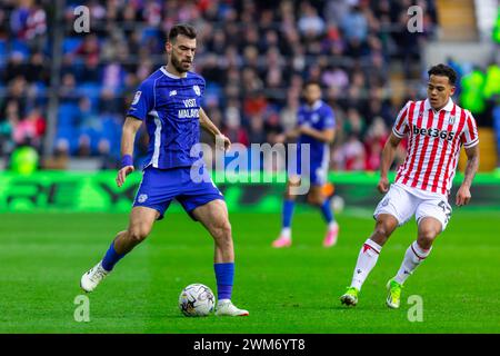 Cardiff, Royaume-Uni. 24 février 2024. Dimitrios Goutas de Cardiff City (l) sous la pression de million Manhoef de Stoke City lors du match de championnat EFL Skybet, Cardiff City v Stoke City au Cardiff City Stadium de Cardiff, pays de Galles, samedi 24 février 2024. Cette image ne peut être utilisée qu'à des fins éditoriales. Usage éditorial uniquement, photo par crédit : Andrew Orchard sports Photography/Alamy Live News Banque D'Images