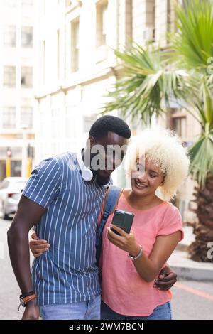 Un couple biracial diversifié partage un moment en plein air dans la ville Banque D'Images