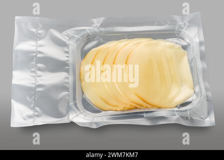 Fromage provolone tranché dans un plateau en plastique emballé sous vide isolé sur gris avec chemin de découpage inclus Banque D'Images