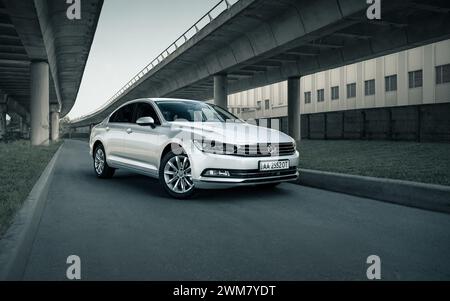 Volkswagen Passat argent sous deux ponts. Perspective vue de trois quarts avant de la berline allemande en milieu urbain. Banque D'Images
