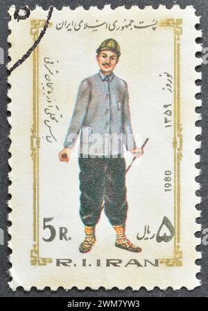 Timbre-poste oblitéré imprimé par l'Iran, qui montre le costume des hommes, Azerbaïdjan oriental, Festival du nouvel an, vers 1980. Banque D'Images