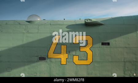 Numéro 43 écrit sur le côté d'un vieil avion militaire. Surface métallique verte avec rivets. Banque D'Images