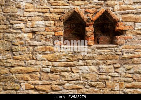 Vieux mur de pierre avec deux fenêtres. Texture d'arrière-plan. Gros plan. Banque D'Images
