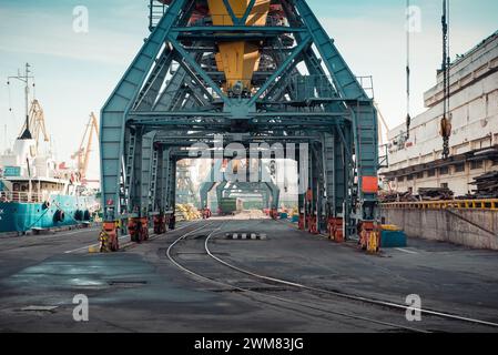 Portiques et cargo amarrés au port maritime. Sale infrastructure portuaire industrielle tôt le matin. Banque D'Images