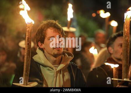 Jérusalem, Israël. 24 février 2024. Les participants à une manifestation appelant le gouvernement israélien à conclure un accord avec le Hamas, pour renvoyer les otages chez eux. La figure principale est ayoung homme tenant une torche et sont entourés de fumée. Banque D'Images