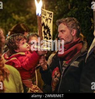 Jérusalem, Israël. 24 février 2024. Les participants à une manifestation appelant le gouvernement israélien à conclure un accord avec le Hamas, pour renvoyer les otages chez eux. Les personnages principaux sont deux parents et un tout-petit tenant une torche. Le panneau en arrière-plan dit : «celui qui a détruit ne peut pas réparer». Crédit : Yoram Biberman/Alamy Live News. Banque D'Images