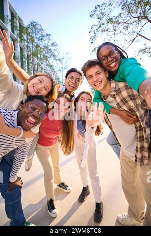 Un grand groupe multiracial d'adolescents prenant un selfie regardant la caméra avant rire Banque D'Images