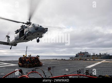 OCÉAN PACIFIQUE (23 février 2024) les marins affectés au porte-avions d'assaut amphibie déployé à l'avant USS America (LHA 6) et les Marines affectés à la 31e Marine Expeditionary Unit (MEU), effectuent un réapprovisionnement vertical avec le cargo USNS Carl Brashear (T-AKE-7) tout en menant des opérations de routine dans l'océan Pacifique, le 23 février. America, navire chef de file de l'America Amphibious Ready Group, opère dans la zone d'opérations de la 7e flotte américaine. La 7e flotte américaine est la plus grande flotte numérotée déployée vers l’avant de l’US Navy, et interagit et opère régulièrement avec des alliés et des partenaires en preser Banque D'Images