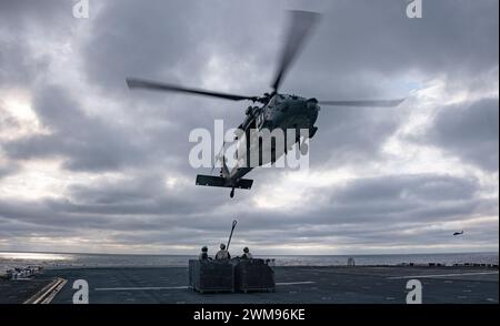 OCÉAN PACIFIQUE (23 février 2024) les marins affectés au porte-avions d'assaut amphibie déployé à l'avant USS America (LHA 6) et les Marines affectés à la 31e Marine Expeditionary Unit (MEU), effectuent un ravitaillement vertical avec le cargo USNS Carl Brashear (T-AKE-7) tout en menant des opérations de routine, le 23 février. America, navire chef de file de l'America Amphibious Ready Group, opère dans la zone d'opérations de la 7e flotte américaine. La 7e flotte américaine est la plus grande flotte numérotée déployée vers l’avant de l’US Navy, et interagit et opère régulièrement avec des alliés et des partenaires pour préserver un espace libre et ouvert Banque D'Images