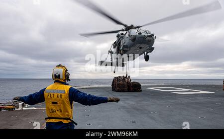 OCÉAN PACIFIQUE (23 février 2024) L'aviateur Jacob Wyatt, de Saint-Pétersbourg, en Floride, affecté au porte-avions amphibie déployé à l'avant USS America (LHA 6) dirige un hélicoptère MH-60S de l'escadron de combat maritime d'hélicoptères (HSC) 25, au cours d'un réapprovisionnement vertical avec le navire de cargaison sèche USNS Carl Brashear (T-AKE-7) lors d'opérations de routine dans l'océan Pacifique, le 23 février. America, navire chef de file de l'America Amphibious Ready Group, opère dans la zone d'opérations de la 7e flotte américaine. La 7e flotte américaine est la plus grande flotte numérotée déployée vers l'avant de l'US Navy, et régulièrement i Banque D'Images