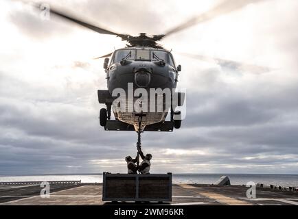 OCÉAN PACIFIQUE (23 février 2024) les marins affectés au porte-avions d'assaut amphibie déployé à l'avant USS America (LHA 6) et les Marines affectés à la 31e Marine Expeditionary Unit (MEU), effectuent un réapprovisionnement vertical avec le cargo USNS Carl Brashear (T-AKE-7) tout en menant des opérations de routine dans l'océan Pacifique, le 23 février. America, navire chef de file de l'America Amphibious Ready Group, opère dans la zone d'opérations de la 7e flotte américaine. La 7e flotte américaine est la plus grande flotte numérotée déployée vers l’avant de l’US Navy, et interagit et opère régulièrement avec des alliés et des partenaires en preser Banque D'Images