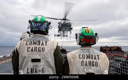 OCÉAN PACIFIQUE (23 février 2024) les marins affectés au porte-avions d'assaut amphibie déployé à l'avant USS America (LHA 6) et les Marines affectés à la 31e Marine Expeditionary Unit (MEU), effectuent un réapprovisionnement vertical avec le cargo USNS Carl Brashear (T-AKE-7) tout en menant des opérations de routine dans l'océan Pacifique, le 23 février. America, navire chef de file de l'America Amphibious Ready Group, opère dans la zone d'opérations de la 7e flotte américaine. La 7e flotte américaine est la plus grande flotte numérotée déployée vers l’avant de l’US Navy, et interagit et opère régulièrement avec des alliés et des partenaires en preser Banque D'Images