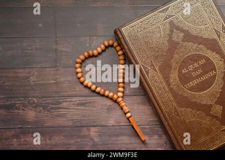 Livre sacré islamique Coran sur fond de table en bois avec tasbih. Ramadan kareem / Eid Moubarak concept. Banque D'Images