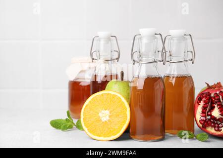 Savoureux kombucha, fruits frais et menthe sur table blanche Banque D'Images