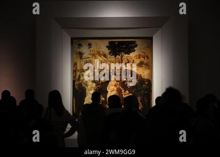 Florence, Italie - 8 février 2024 : visiteurs regardant la célèbre peinture 'Adoration des Mages' de Léonard de Vinci à la galerie des Offices Banque D'Images