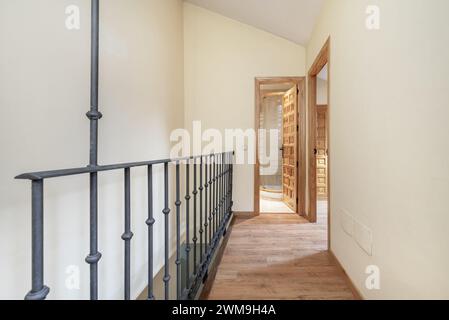 Escalier intérieur d'une maison résidentielle duplex avec balustrades en métal forgé et portes en panneaux de bois de style castillan Banque D'Images