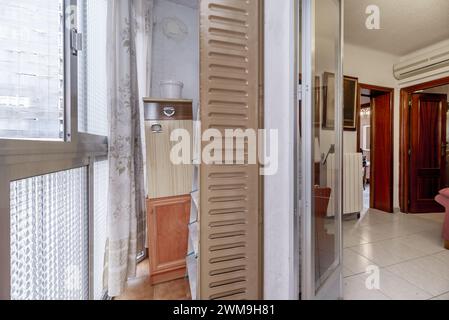 Un petit balcon terrasse avec volets en métal et portes en verre et en aluminium Banque D'Images