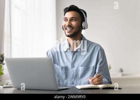 Homme écoutant cours audio, améliorer les compétences en langues étrangères en utilisant Internet Banque D'Images