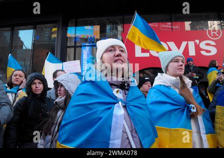 Des manifestants pro-ukrainiens scandent des slogans et brandissent des drapeaux ukrainiens lors d'un rassemblement à Times Square. Des manifestants se sont rassemblés à Manhattan, New York City, à l'occasion des deux ans de l'invasion russe de l'Ukraine. Les manifestants ont condamné l'invasion et se sont opposés au président russe Vladimir Poutine. Le week-end dernier, les forces russes ont capturé la ville ukrainienne orientale d'Avdiivka située sur la ligne de front. La perte de la ville survient alors qu'un paquet d'aide de 60 milliards de dollars pour l'Ukraine de la part des États-Unis a été bloqué à la suite de désaccords au Congrès. Le président ukrainien, Volodymyr Zelenskyy, a déclaré les troupes ukrainiennes Banque D'Images