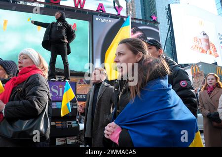 Des manifestants pro-ukrainiens scandent des slogans et brandissent des drapeaux ukrainiens lors d'un rassemblement à Times Square. Des manifestants se sont rassemblés à Manhattan, New York City, à l'occasion des deux ans de l'invasion russe de l'Ukraine. Les manifestants ont condamné l'invasion et se sont opposés au président russe Vladimir Poutine. Le week-end dernier, les forces russes ont capturé la ville ukrainienne orientale d'Avdiivka située sur la ligne de front. La perte de la ville survient alors qu'un paquet d'aide de 60 milliards de dollars pour l'Ukraine de la part des États-Unis a été bloqué à la suite de désaccords au Congrès. Le président ukrainien, Volodymyr Zelenskyy, a déclaré les troupes ukrainiennes Banque D'Images