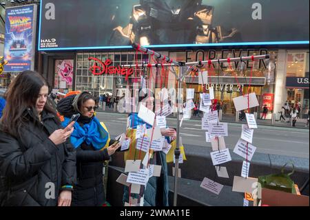 NEW YORK, NEW YORK - 24 FÉVRIER : les gens regardent accrocher mobile marquant les événements et les pertes au cours des deux dernières années de combats actifs lors d'un rassemblement pour l'Ukraine à l'occasion du deuxième anniversaire de l'invasion russe de l'Ukraine à Times Square le 24 février 2024 à New York. Entrant dans sa troisième année, la guerre inlassable de la Russie contre l'Ukraine a soulevé des inquiétudes quant à la durée pendant laquelle les pays occidentaux continueront à fournir des armes et d'autres formes de soutien à Kiev. La fourniture de munitions, d'armes et de main-d'œuvre est maintenant un facteur critique dans un conflit qui a fait plus d'un demi-million de victimes et causé la grande préa Banque D'Images