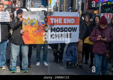 NEW YORK, NEW YORK - 24 FÉVRIER : les gens tiennent une pancarte "LA FIN DE L'EMPIRE DE MOSCOU" lors d'un rassemblement pour l'Ukraine à l'occasion du deuxième anniversaire de l'invasion russe de l'Ukraine à Times Square le 24 février 2024 à New York. Entrant dans sa troisième année, la guerre inlassable de la Russie contre l'Ukraine a soulevé des inquiétudes quant à la durée pendant laquelle les pays occidentaux continueront à fournir des armes et d'autres formes de soutien à Kiev. La fourniture de munitions, d’armes et de main-d’œuvre est aujourd’hui un facteur critique dans un conflit qui a fait plus d’un demi-million de victimes et provoqué des déplacements massifs de civils. Banque D'Images