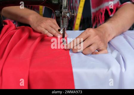 Le tailleur fabrique le drapeau national indonésien avant le jour de l'indépendance Banque D'Images