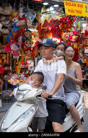 Famille à moto dans le vieux quartier de Hanoi, Vietnam Banque D'Images