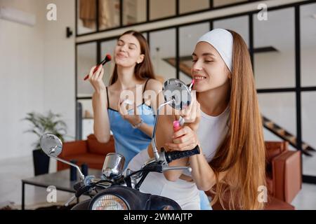 Jeunes amis filles insouciants faisant du maquillage appréciant le temps amusant à la maison Banque D'Images