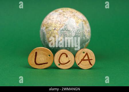 Concept écologique. Sur un fond vert il y a un globe terrestre et des ronds en bois avec l'inscription - LCA Banque D'Images