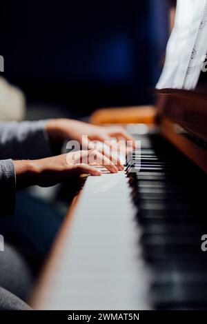 joueur de piano dans la lumière beutiful vous pouvez seulement voir les mains des joueurs qui pratique la leçon de piano. Banque D'Images