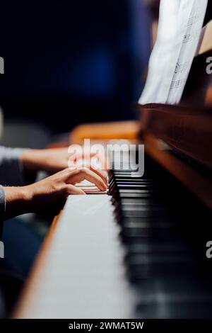 joueur de piano dans la lumière beutiful vous pouvez seulement voir les mains des joueurs qui pratique la leçon de piano. Banque D'Images