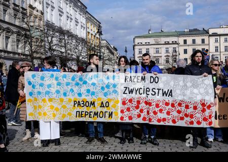 Cracovie, Pologne. 24 février 2024. Les Ukrainiens et leurs partisans tiennent une banderole pendant la manifestation. Une marche de soutien et d'union pour le deuxième anniversaire de l'invasion à grande échelle de l'armée russe sur l'Ukraine a eu lieu sur la place du Vieux marché dans la vieille ville de Cracovie. La marche vise à montrer l'unité du peuple polonais ukrainien ainsi que le soutien de l'opposition russe et biélorusse à la lutte ukrainienne. Crédit : SOPA images Limited/Alamy Live News Banque D'Images