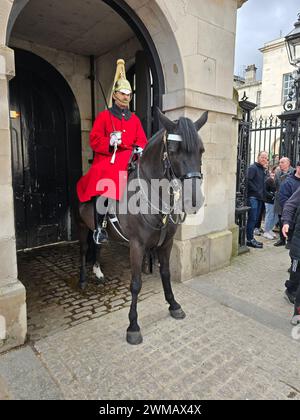 Soldats du sauveteur du roi à la relève de la garde dans leurs uniformes de cérémonie portant de longs manteaux pour la période froide de l'année à Whitehall, Londres, Royaume-Uni Banque D'Images