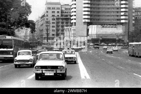 Bucarest, Roumanie, approx. 1980. Véhicules circulant sur le boulevard I.C. Bratianu à travers la place de l'Université dans le centre-ville de Bucarest. Banque D'Images