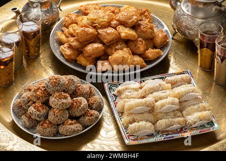 Table de thé marocaine traditionnelle en laiton avec assiettes pâtisseries biscuits et thé Banque D'Images