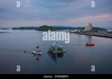 Oslo, Norvège, 20 juin 2023 : des voiliers naviguent dans les eaux du fjord d'Oslo près de la sculpture flottante en acier inoxydable et en verre She Lies, Designed and Banque D'Images