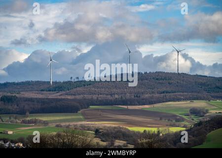 WindEnergie im Einklang mit der Natur 25.02.24, Selters : Symbolfoto, Illustrationsbild, Symbolbild, Illustrationsfoto Windenergie im Einklang mit der Natur Dieses Bild zeigt drei beeindruckende Windräder, die aus einem dichten Wald herausragen. IM Vordergrund erstrecken sich weite Felder und Grüne Wiesen, die ein harmonisches Bild der nachhaltigen Energiegewinnung inmitten der Natur zeichnen. AM Horizont bilden sich malerische Quellwolken, die dem Himmel eine dramatische Kulisse verleihen und die Verbindung zwischen Himmel und Erde symbolisieren. Selters Hessen Allemagne *** énergie éolienne in harmo Banque D'Images