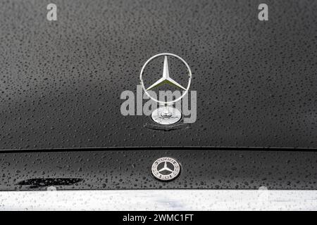 Mercedes-logo auf nasser Motorhaube 25.02.24, Limburg : Symbolfoto, Illustrationsbild, Symbolbild, Illustrationsfoto Mercedes-logo auf nasser Motorhaube Das ikonische Mercedes-Benz logo sowie der markante Stern prangen im Zentrum einer teilweise sichtbaren, schwarzen Motorhaube, die mit glänzenden Regentropfen bedeckt. DAS Spiel von Licht und Wasser betont das markante Emblem und verleiht dem Bild eine luxuriöse und elegante Atmosphäre. Limburg Hessen Allemagne *** logo Mercedes sur capot mouillé 25 02 24, Limburg symbole photo, illustration image, symbole image, illustration photo logo Mercedes sur w Banque D'Images