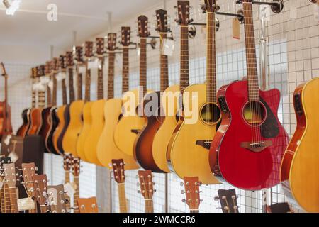 Beaucoup de guitares acoustiques différentes accrochées sur le mur du magasin de musique. Gros plan. Banque D'Images