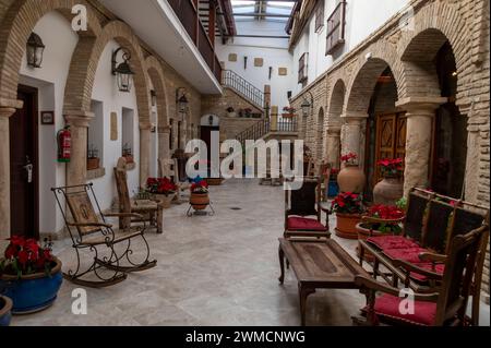 Intérieur d'un patio d'hôtel d'influence mauresque (cour) avec ses grandes arches mauresques et meublé avec des meubles mauresques et des pots de plantes Banque D'Images