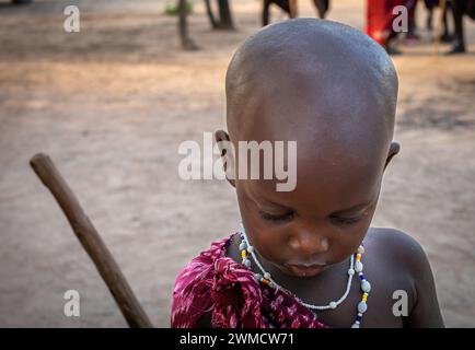 Un gros plan d'un jeune garçon Massaï vêtu d'un shuka regardant vers le bas dans son village de Mikumi, en Tanzanie Banque D'Images